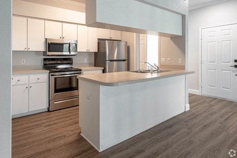 a kitchen with white cabinets and stainless steel appliances